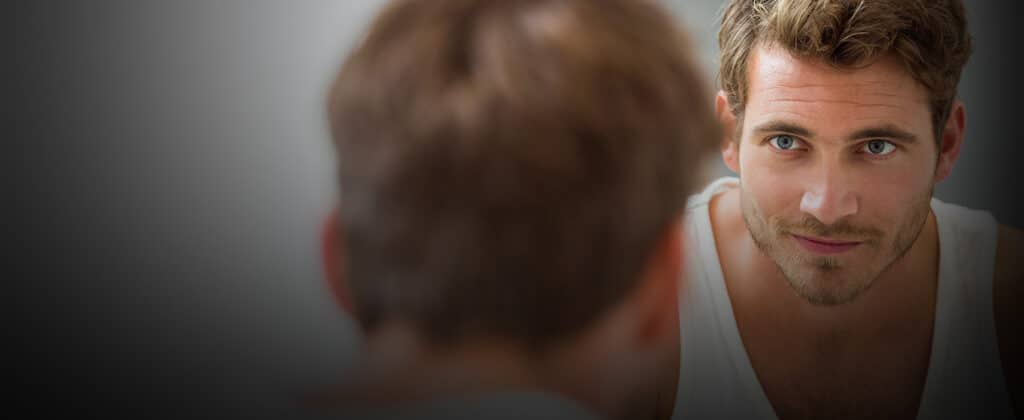 A man looking at himself in the mirror