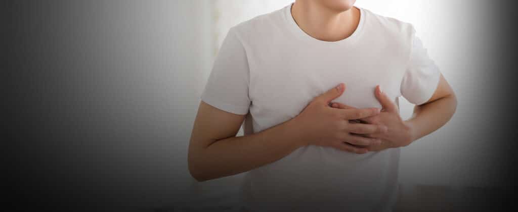 A man in a white shirt holding his chest