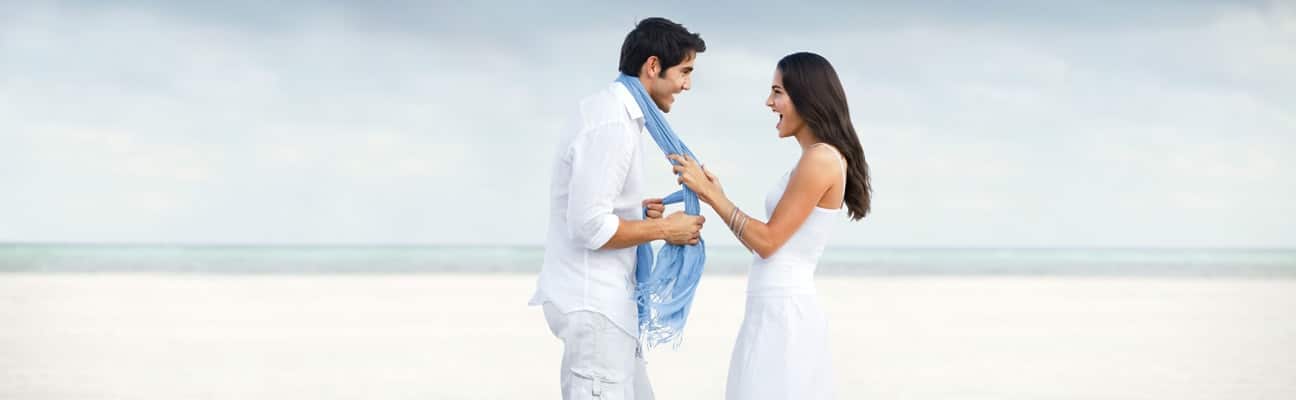 Man at the beach feeling confident with his girl friend,