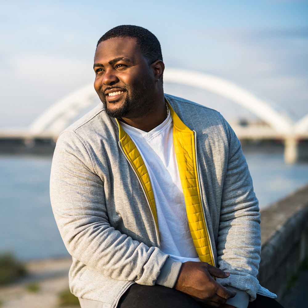 man in a gray sweater sitting outside